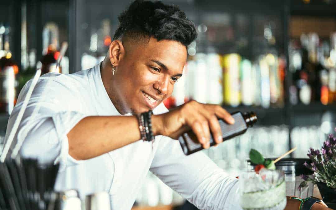 pos smiling bartender serving cocktail