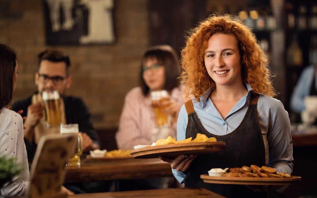pos young happy waitress serving her guest in a pub