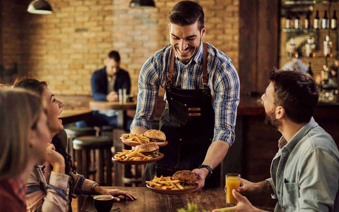 self service happy waiter serving food to group of cheerful friends